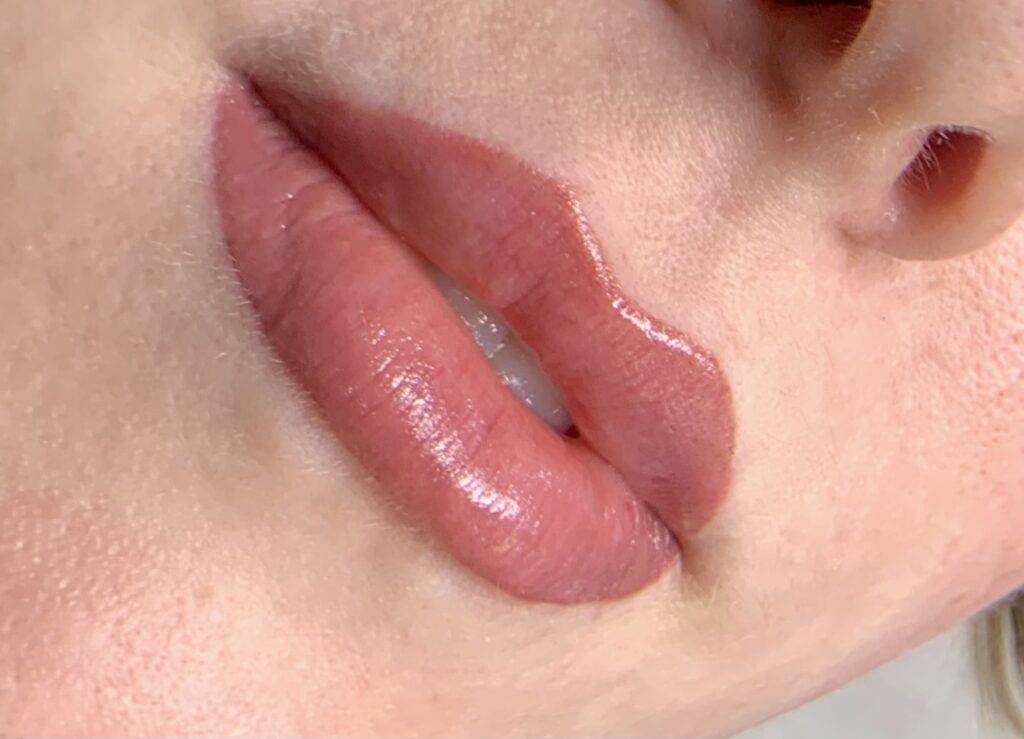Soft pink lip blush with a natural, glossy finish, showing smooth color blending and subtle shape definition on the lips.